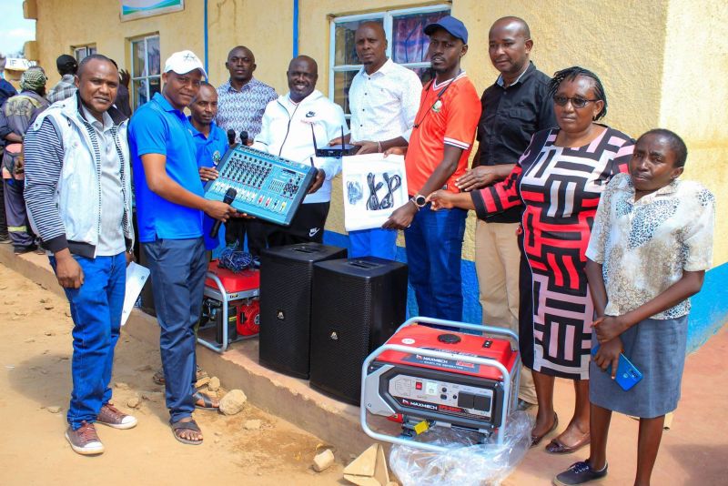 County officials hand over a sound mixer, speakers and generators to a youth group